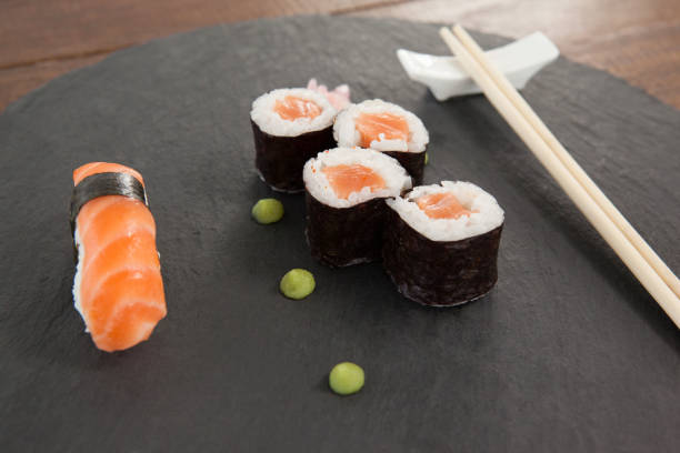 istock Set of assorted sushi served with chopsticks on grey stone slate 648039468