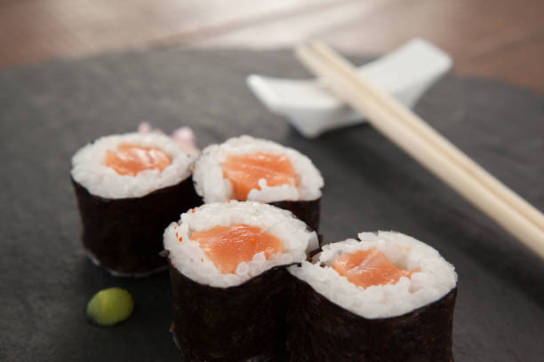istock Four nigiri sushi served with chopsticks on black stone slate 648039562