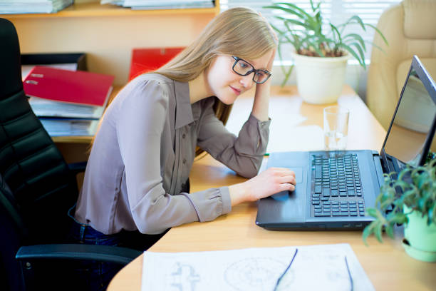 istock worker sitting in front of laptop 648043460
