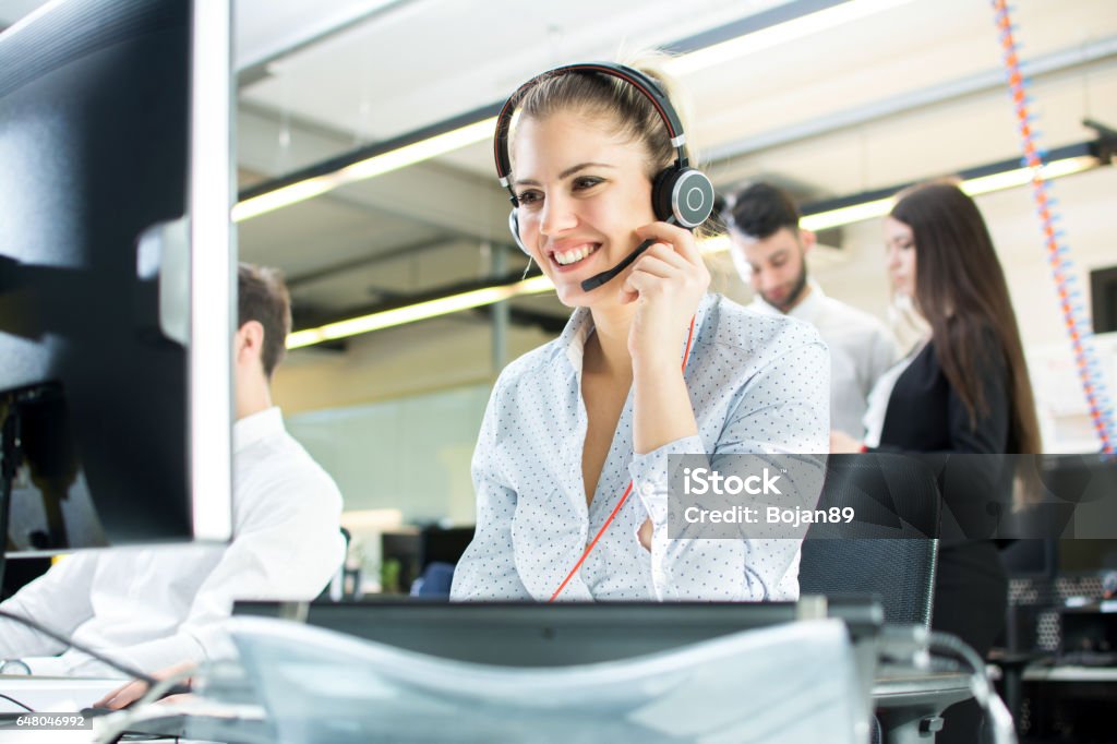 Smiling agent woman with headsets. Portrait of call center worker at office. Call Center Stock Photo