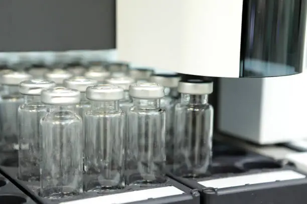 Photo of Bottles check on the quality of the suspension. Quality Control Laboratory medicine. Chromatograph operation.