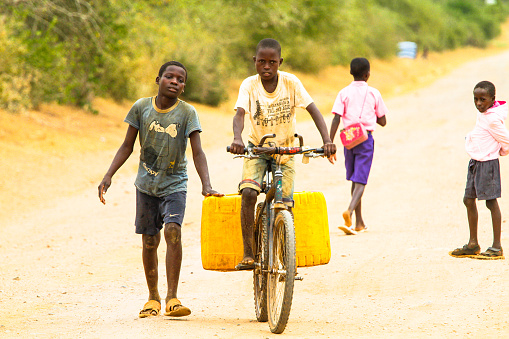 MALINDI, KENYA - January 25, 2017: A young boy is carrying water from a nearest hydrant to his home. Malindi region, Kenya.