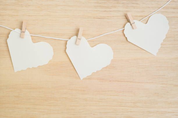 istock Three paper hearts on wooden background 648069552