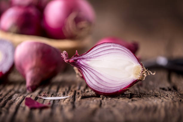 istock Onion. Red onions on very old oak wood board. Selective focus 648077716
