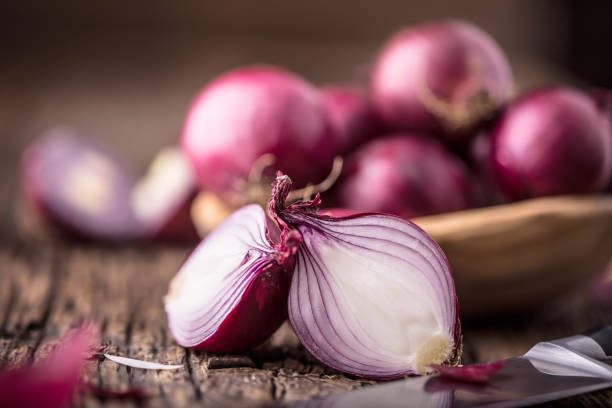 istock Onion. Red onions on very old oak wood board. Selective focus 648077730