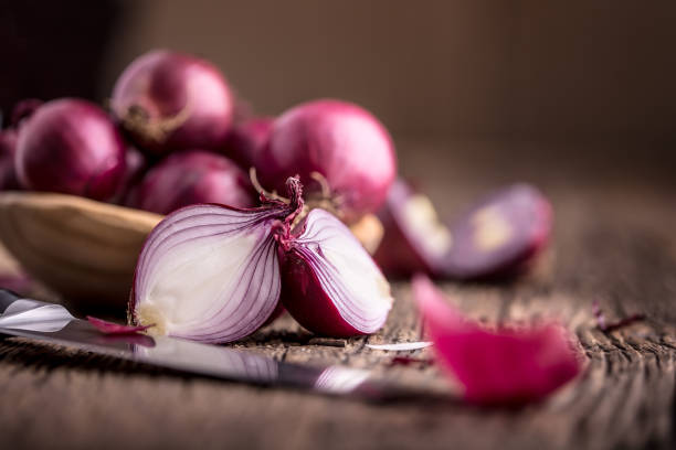 istock Onion. Red onions on very old oak wood board. Selective focus 648077734