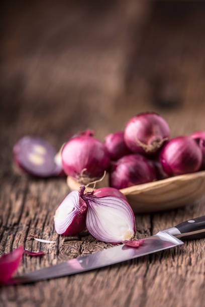 istock Onion. Red onions on very old oak wood board. Selective focus 648077770