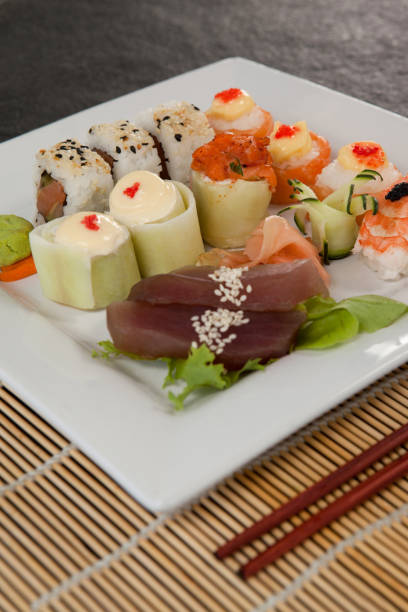 istock Assorted sushi set served with chopsticks in white plate on sushi mat 648080726