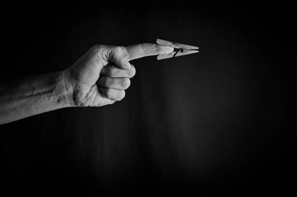 istock Old wooden clothespin on the index finger indicates the direction. 648092564