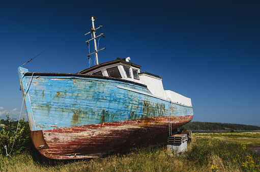 An abandoned cape islander fishing boat near a small fishing village.