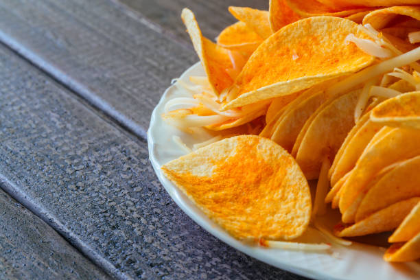 Bowl of potato chips in black wooden background Bowl of potato chips in a black wooden background spectrum field stock pictures, royalty-free photos & images