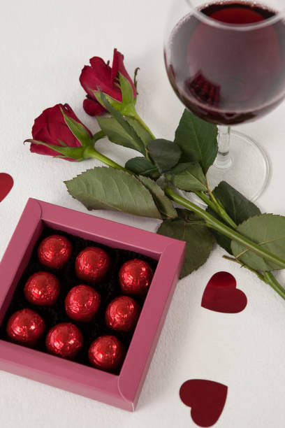 istock Bunch of roses, wine glass and assorted chocolate box 648112752