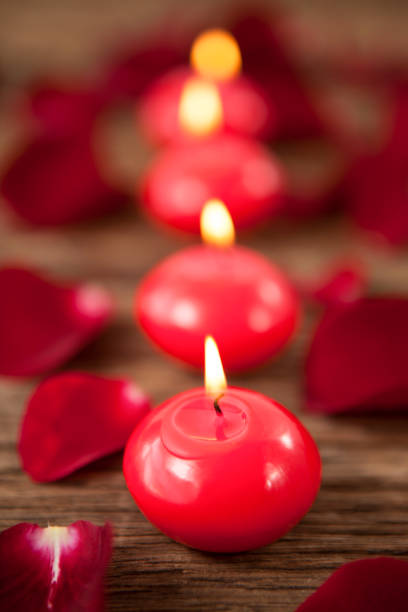 istock Red wax candles surrounded with rose petals 648117752