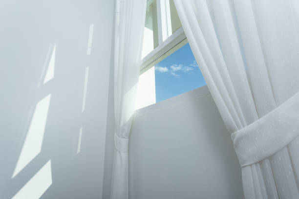 istock white curtain on the window with blue sky 648123086