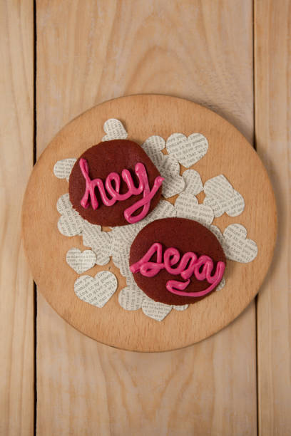 istock Cookies iced with pink cream displaying hey sexy 648135250