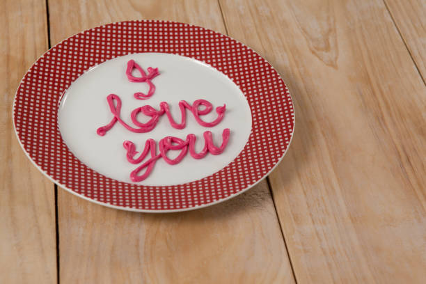 istock I love you text written with pink cream on plate 648135674