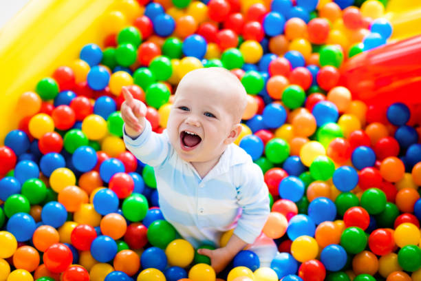 kind spelen in de ballenbak op indoor speeltuin - babybox stockfoto's en -beelden