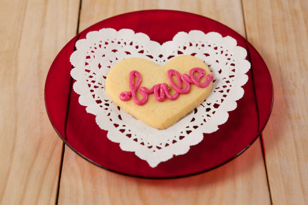 istock Heart shaped cookie iced with pink cream in text babe 648136534