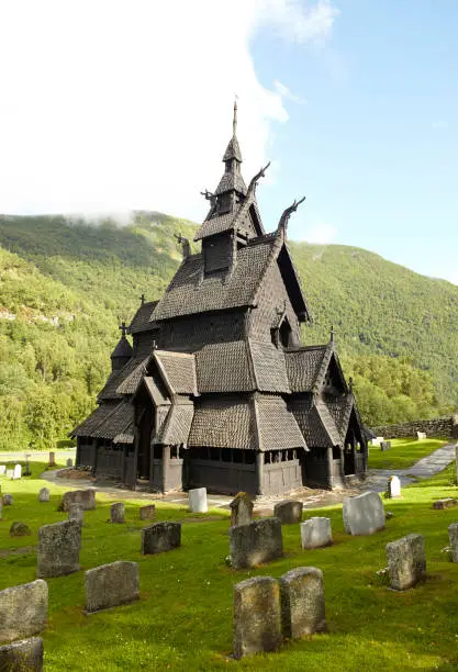 Photograph of the stavkirke (wooden church) of Borgun in Lærdal (Sogn og Fjordane, Norway). Medieval temple, dating from the twelfth century. It currently functions as a museum. It is the masterpiece of medieval stavkirke that have survived to the present day. It has a monumental design, with its characteristic sextuplo staggering ceiling with decoration in the form of dragon heads. It is the best preserved, the best known and one of the most visited. World Heritage. Photograph taken on a sunny summer day. Vertical format. Camera: Canon EOS 5D.