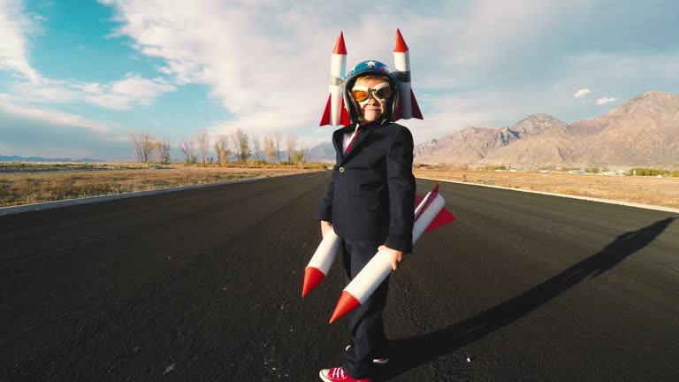 Boy Businessman Holding Rockets Imagines Flying