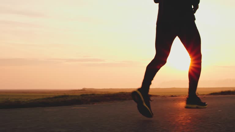 MS Legs of an unrecognizable jogger on country road