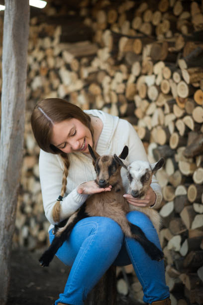 istock Eastern Europe: Lifestyle-Young woman hugging kid goat 648168882