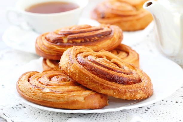 istock Baked sweet cinnamon rolls with cup of tea 648171448
