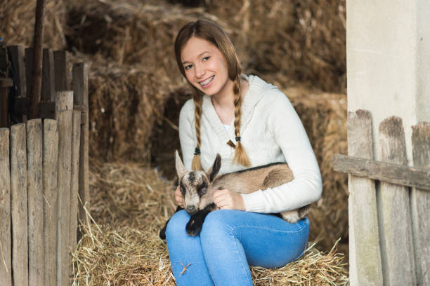 istock Eastern Europe: Lifestyle-Young woman hugging kid goat 648175704