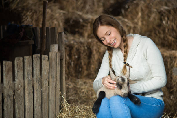 istock Eastern Europe: Lifestyle-Young woman hugging kid goat 648182272