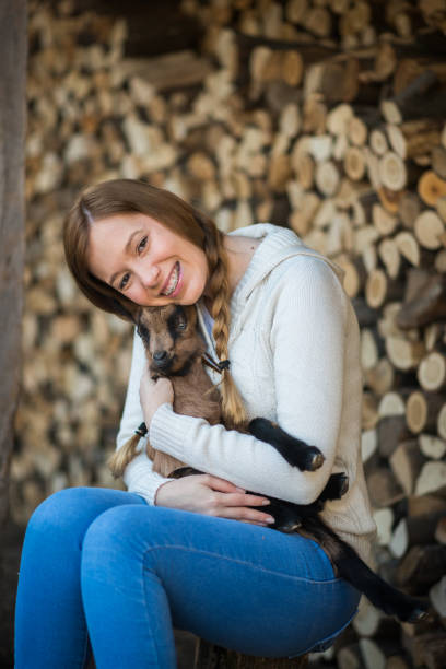 istock Eastern Europe: Lifestyle-Young woman hugging kid goat 648182326