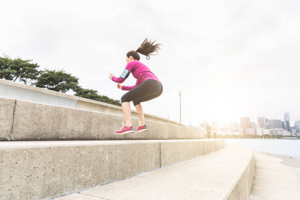 istock Young woman doing legs exercises with Chicago skyline on background 648188472