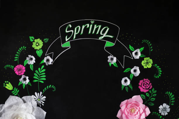 istock Decorative flowers from paper on a black background. Decorative frame from paper flowers. Drawing chalk on a black board 648189168