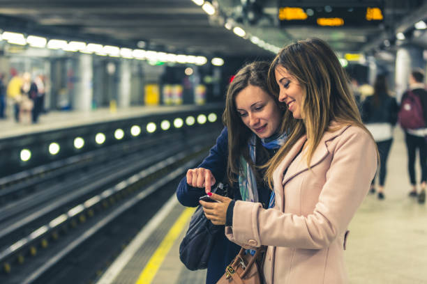 dos chicas en el metro de londres esperando el tren. - subway station railroad station uk passenger fotografías e imágenes de stock