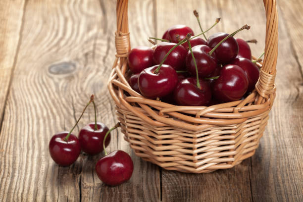 istock Ripe cherries in a basket on an old board 648220900