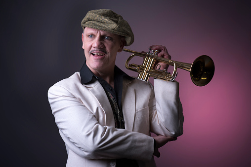 Portrait image of a happy mature jazz man with a trumpet