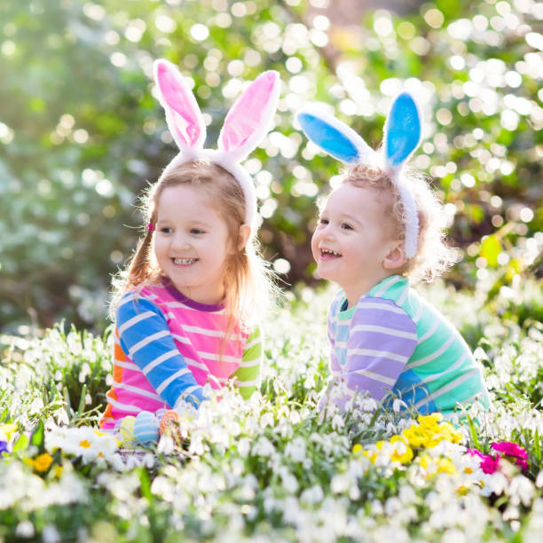 istock Kids on Easter egg hunt in blooming spring garden 648239316