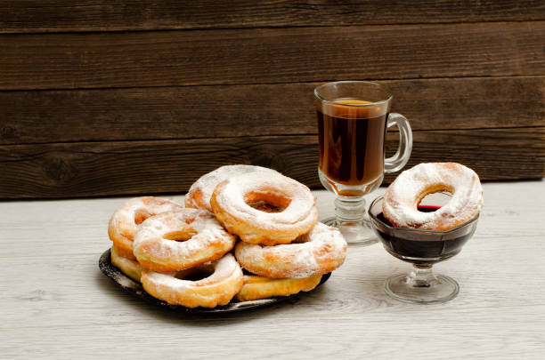 istock Donuts with icing sugar, a mug of tea and currant jam on a wooden background 648251620
