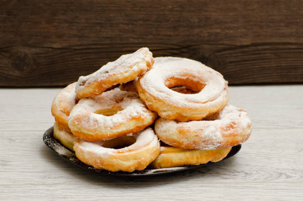 istock Donuts sprinkled with powdered sugar, dark wood background. Close-up, side view 648251724