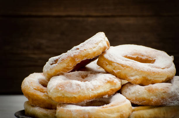 istock Donuts sprinkled with powdered sugar, dark wood background. Close-up, side view 648251808
