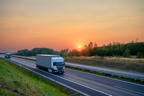 istock White trucks driving on the asphalt highway at sunset 648251890