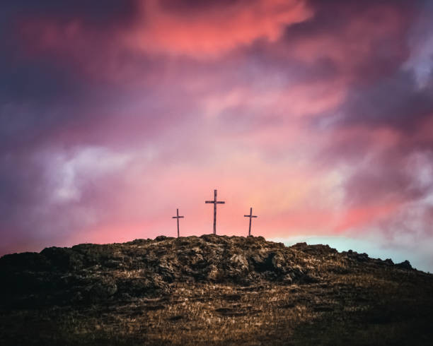Three Crosses On A Rocky Hill Three crosses on top of a rocky hill against a dramatic sky of pink and purple clouds. Symbolic of Easter and Good Friday, holidays celebrated by Christians. butte rocky outcrop photos stock pictures, royalty-free photos & images