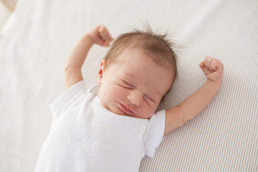 cute baby lying in bed and waking up