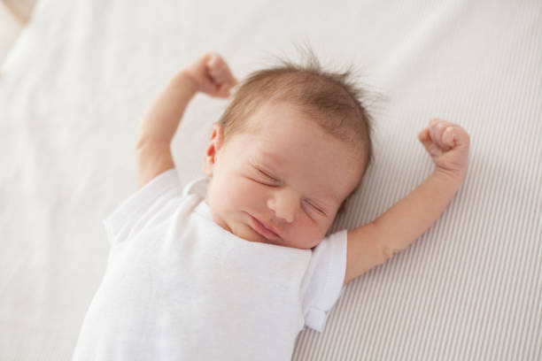 baby waking up cute baby lying in bed and waking up baby sleeping bedding bed stock pictures, royalty-free photos & images