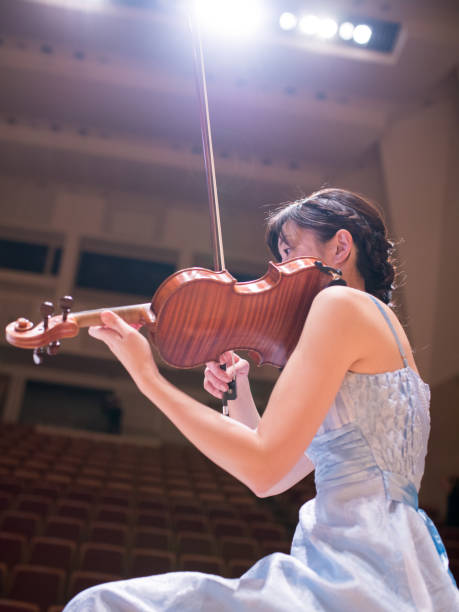 istock Female musician playing violin on concert stage 648265548