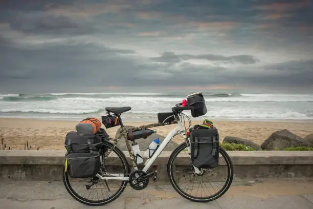 Photo of Bicycle packed for long journey by beach