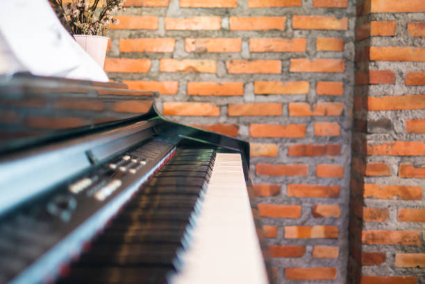 istock Side view piano keyboard. Blur piano foreground. Blur red brick wall background. 648283914