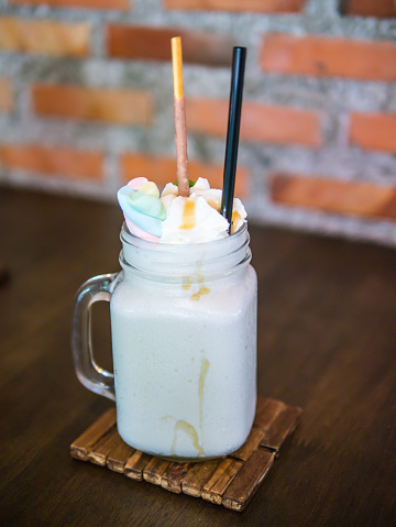 Milkshake topped with whipped cream, marshmallow, and caramel sauce.