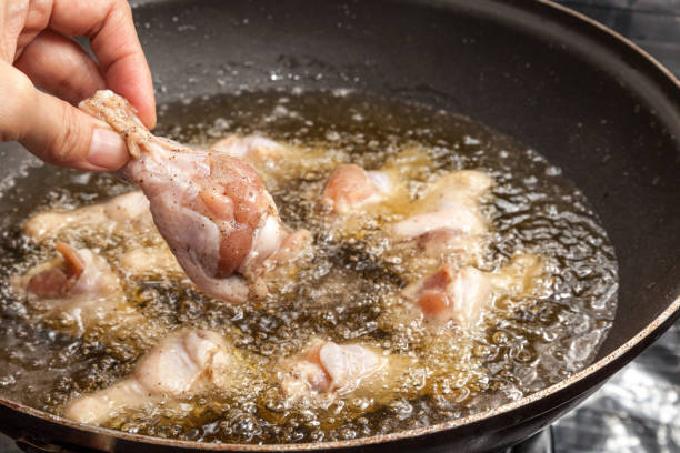 istock Chef is cooking fried chicken wings in the pan 648284860