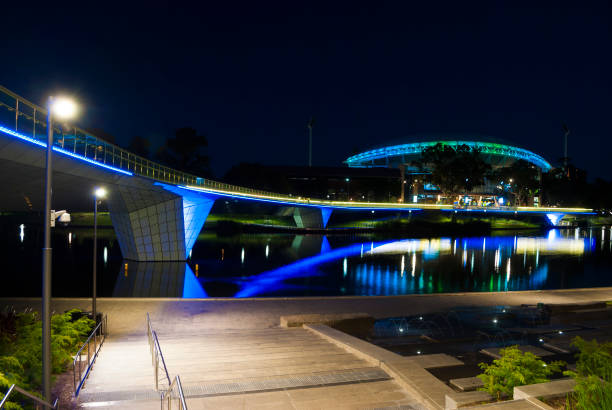 Night time lights on the Adelaide Oval foot bridge and the Adelaide Oval, reflecting on the Torrens river in the CBD of Adelaide in South Australia.