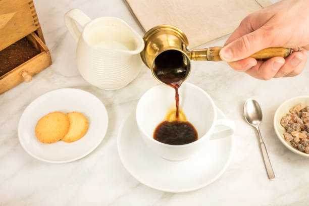 istock Coffee poured into cup, with milk jar and cane sugar 648288428